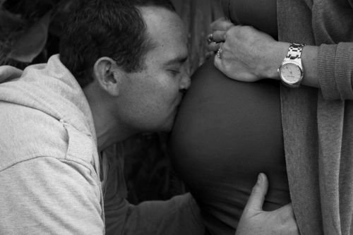 Pai beijando barriga da grávida