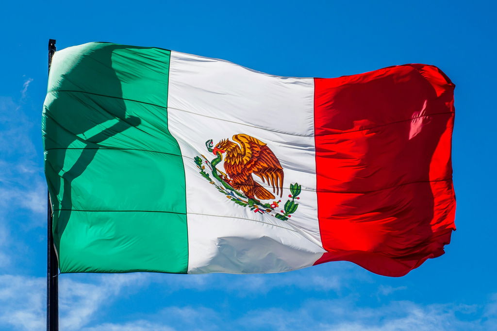 Bandeira do México sob o céu azul.