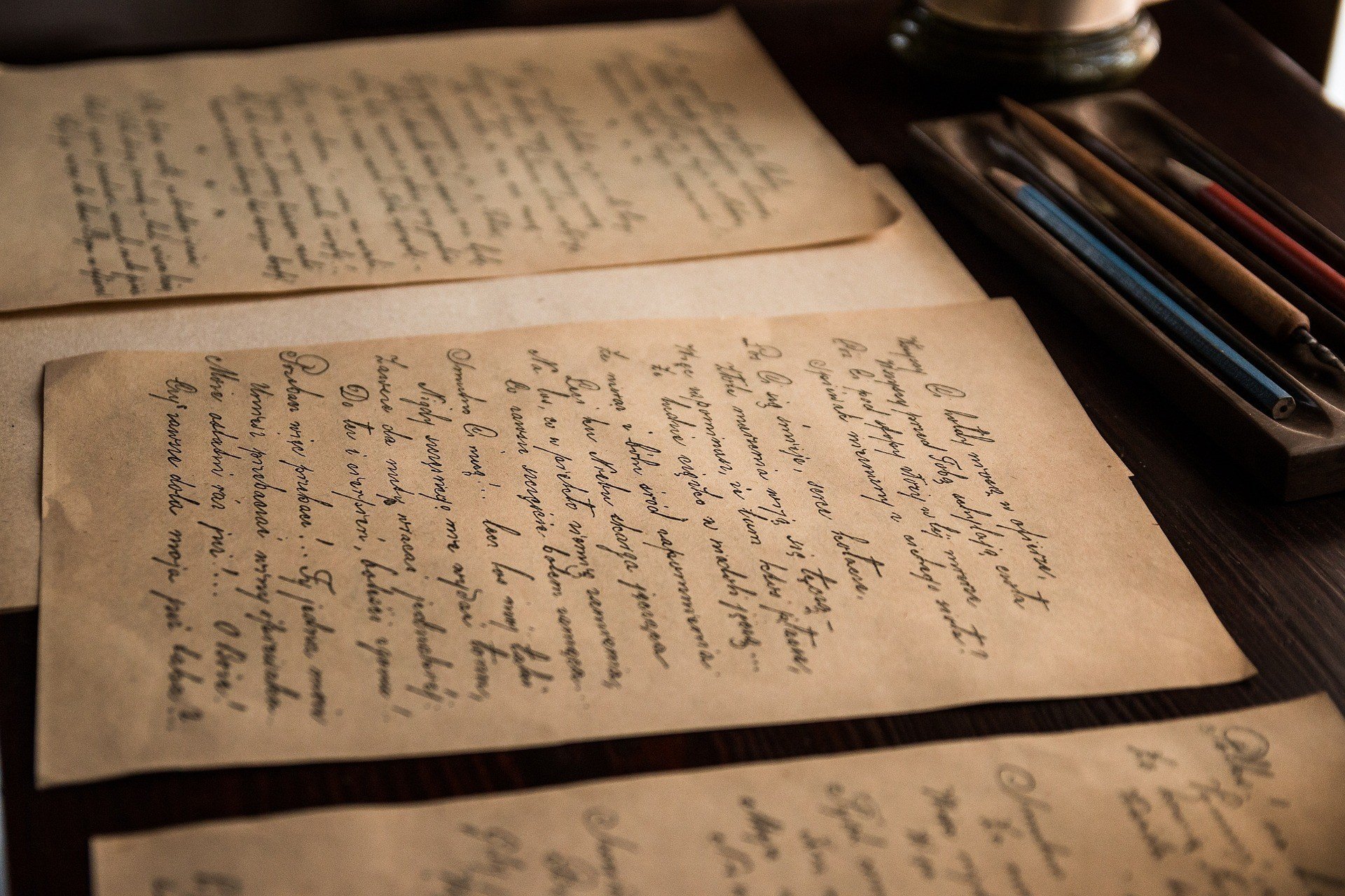 Cartas antigas sobre a mesa, escritas com tinta em papel amarelado.