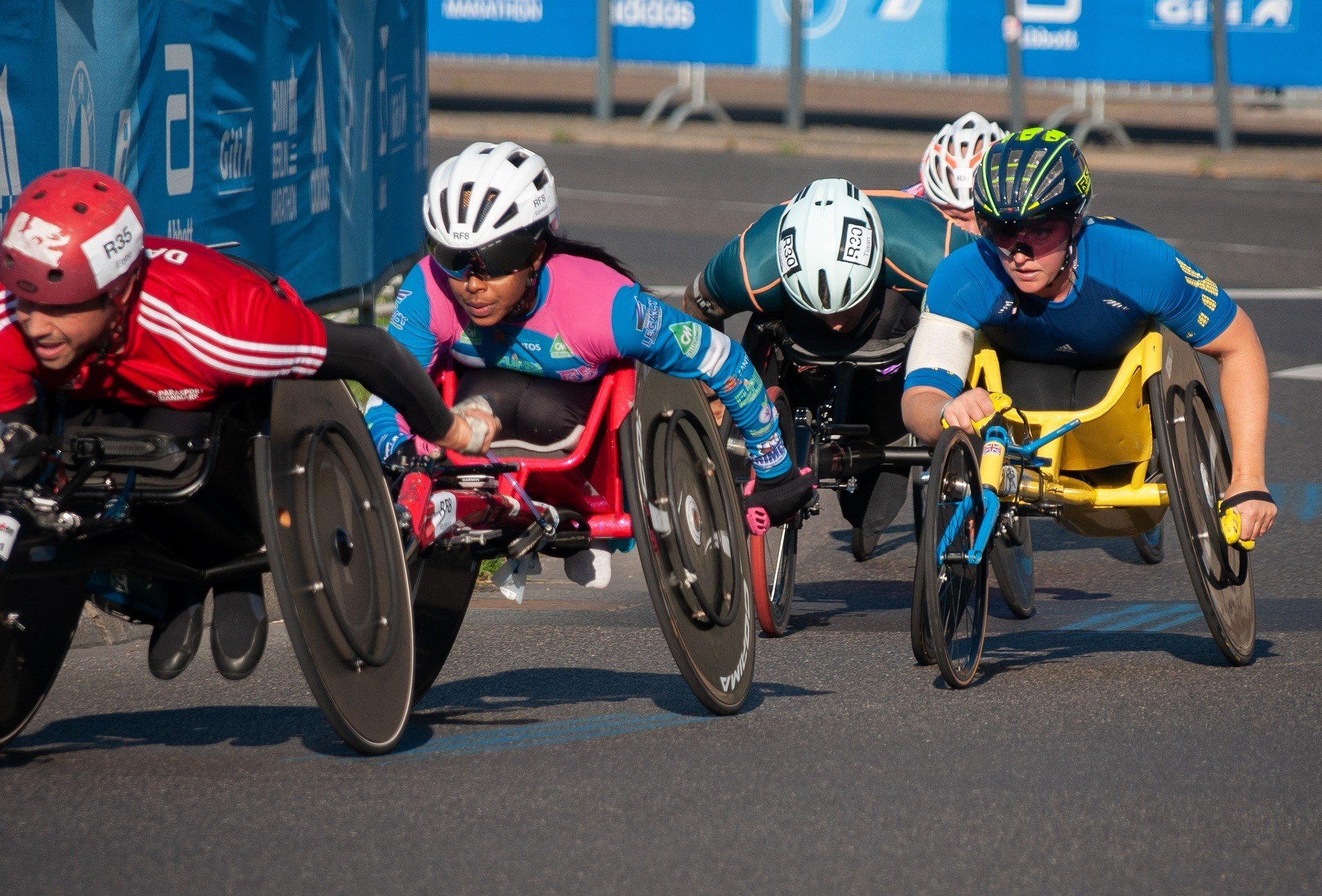 Atletas em cadeiras de rodas competem em uma corrida ao ar livre.