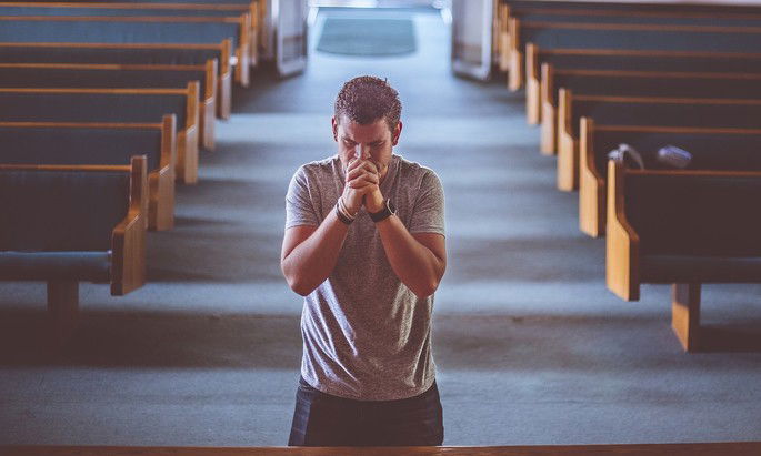 Homem ora na igreja