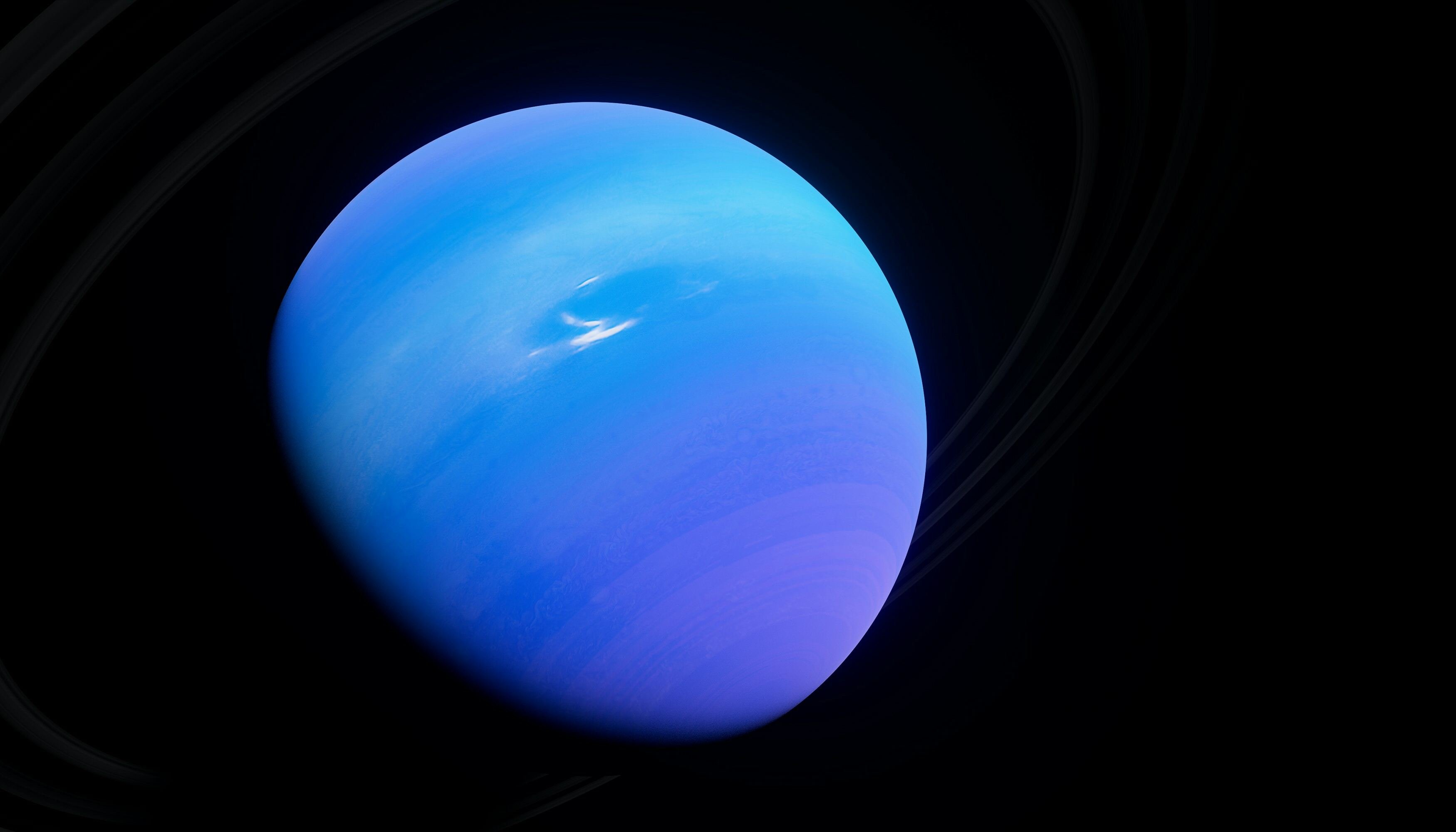 Planeta Netuno, redondo e de cor azul escura, em fundo preto do espaço.