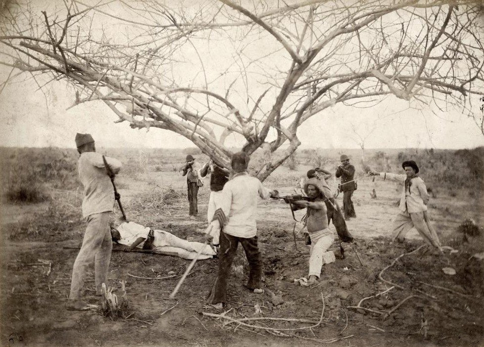 Em preto e branco, dois grupos armados apontam armas um para o outro durante a Guerra de Canudos