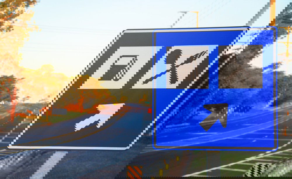 Placa de trânsito em azul com serviços auxiliares.