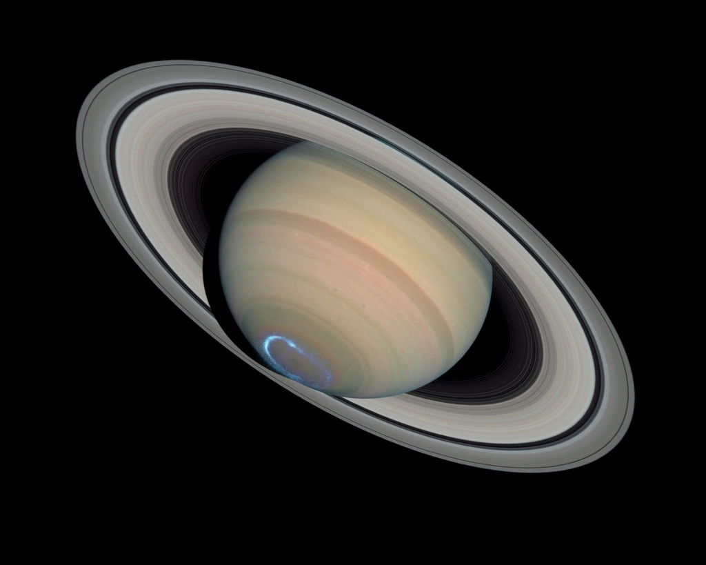 Planeta Saturno, com superfície amarelada e seus anéis, em fundo preto.